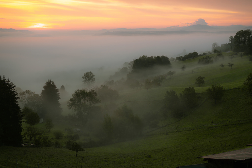 Sonnenaufgang oberhalb Nuglar | Sonnenaufgang ausserhalb von Nuglar mit Wolken und Nebel über dem Tal. - Realisiert mit Pictrs.com