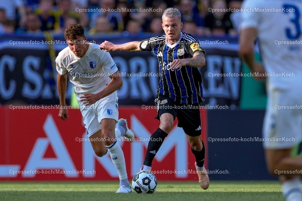 DFB15082501027 | 15.08.2025, Fußball, DFB-Pokal, 1. FC Saarbrücken - 1.FC Magdeburg, Ludwigsparkstadion, Saison 2025 2026: Tobias Müller (1FC Magdeburg #05) im Zweikampf gegen  Florian Pick (1FC Saarbruecken #20)   DFB regulations prohibit any use of photographs as image sequences and or quasi-video.