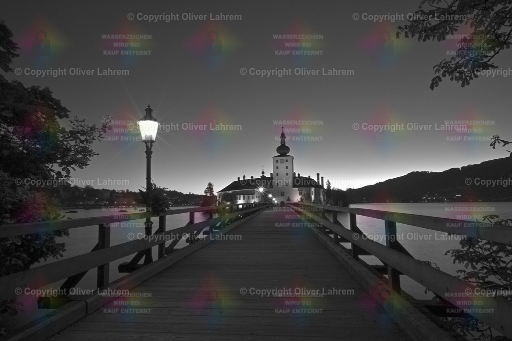 Die Brücke zum Schloss Ort  | Die Laternen auf der Brücke zum Schloss im Traunsee leuchten noch, da beginnt am Horizont die Morgendämmerung.