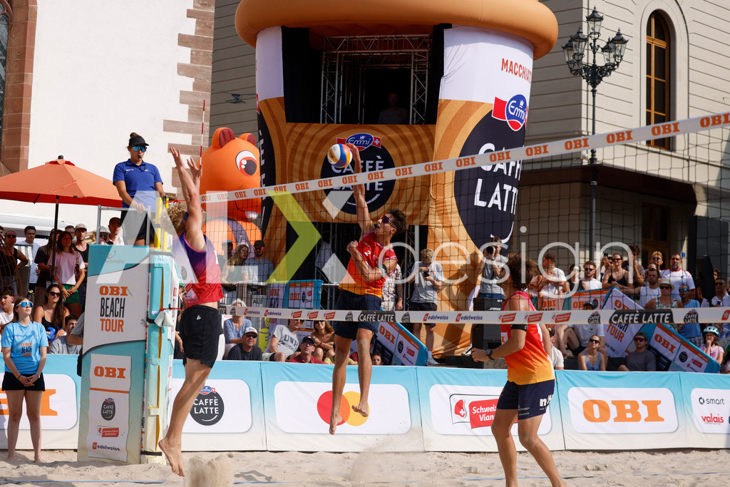 Obi BeachTour 2026 - Basel | BASEL, SWITZERLAND - JULY 19: LUC EMANUEL FLÜCKIGER (SUI) attack / spike against MATHIS KÄLIN (SUI) block during the Obi BeachTour 2026 match between DILLIER / FLÜCKIGER (SUI) and BREER / KÄLIN (SUI) at Barfüsserplatz on July 19, 2026 in Basel, Switzerland. - Realisiert mit Pictrs.com