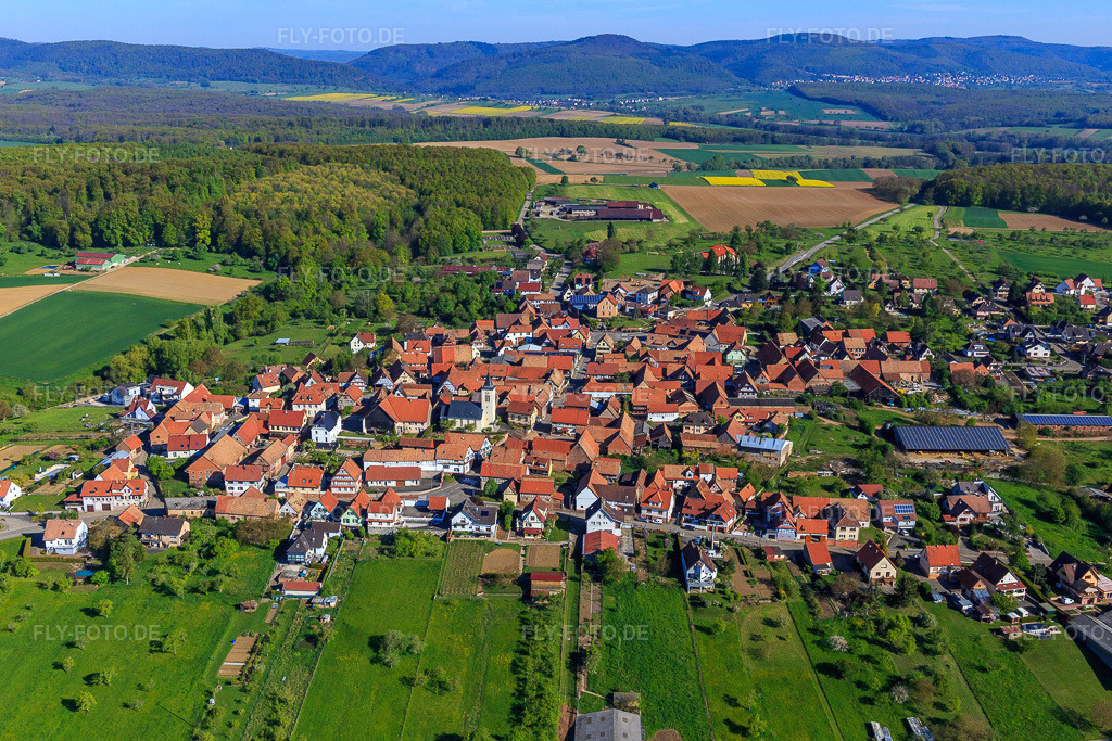 Luftbild: Dorfübersicht aus Süden mit Kirche in Engwiller im Bundesland Bas-Rhin in Frankreich. – Foto: IMG_099439.jpg vom 30.04.2017 durch Werner Riehm/FLY-FOTO.de – Auflösung des Originals: 5245 x 3497 px
