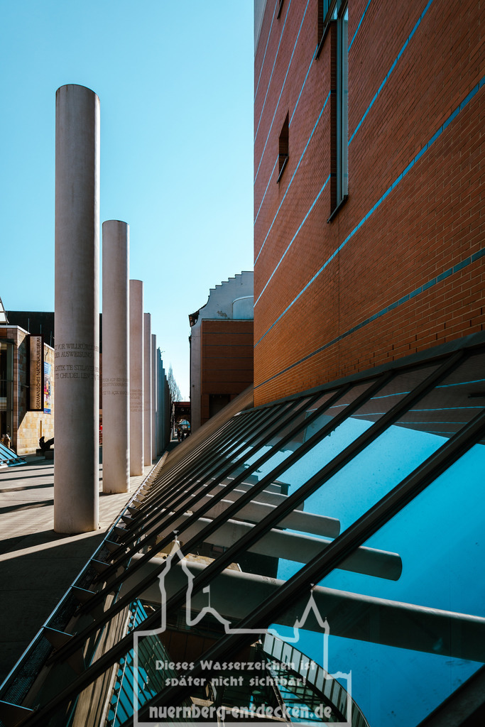 Straße der Menschenrechte  im Frühling | Ein schöner Frühlingstag mit blauen Himmel erzeugt auf der Straße der Menschenrechte in Nürnberg herrliche Reflektionen der Säulen in einem Fenster der Germanischen Nationalmuseums.  - Realisiert mit Pictrs.com