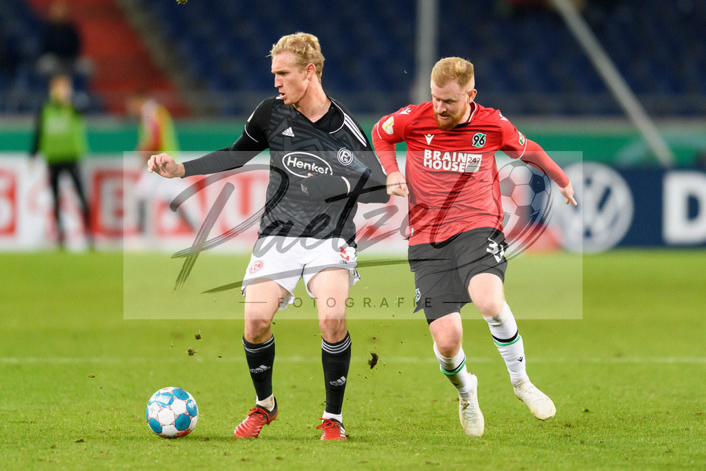 H96DUS20211027_048 | Fussball, Herren: Christoph Klarer (Fortuna Duesseldorf) und Sebastian Kerk (Hannover 96) im Zweikampf bei dem Spiel der 2. Runde im DFB-Pokal zwischen Hannover 96 und Fortuna Duesseldorf in der HDI-Arena am 27.10.2021 in Hannover, Deutschland.DFB / DFL REGULATIONS PROHIBIT ANY USE OF PHOTOGRAPHS AS IMAGE SEQUENCES AND/OR QUASI-VIDEO. - Realisiert mit Pictrs.com