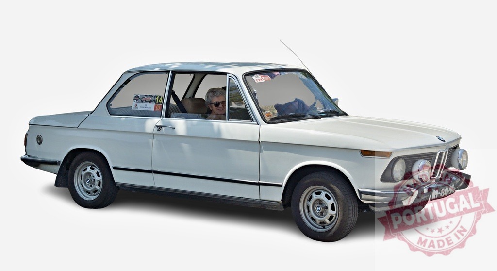 Senior woman driving vintage white BMW 2002 on white background | Elegant senior woman driving classic white BMW 2002 automobile on white background - Realized with Pictrs.com