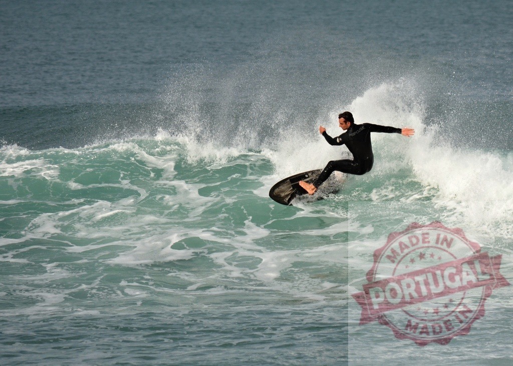 Surfer riding a wave and making splashes in the ocean | Surfer wearing a wetsuit riding a wave and making splashes in the ocean - Realisiert mit Pictrs.com
