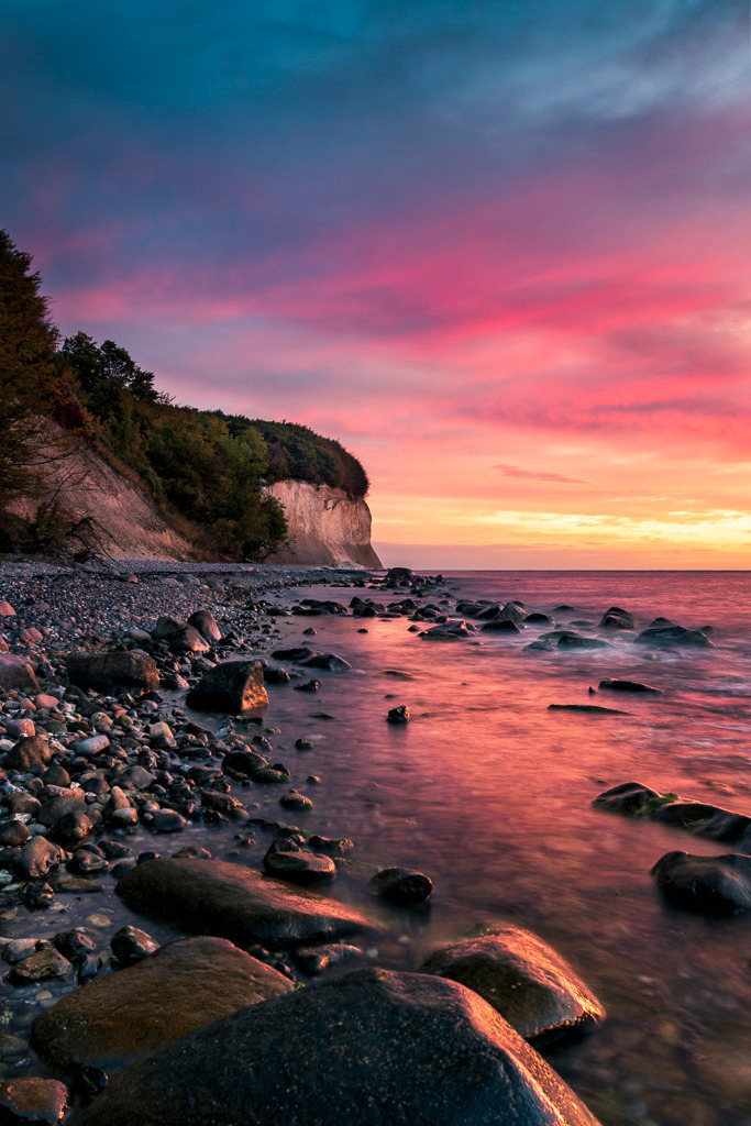 Morgenstimmung an den Kreidefelsen – Rügen | In zarten Rosa- und Blautönen erwacht der Tag an den berühmten Kreidefelsen Rügens. Das weiche Licht des Sonnenaufgangs spiegelt sich im Wasser und lässt die raue Küste in sanfter Schönheit erscheinen. - Realisiert mit Pictrs.com