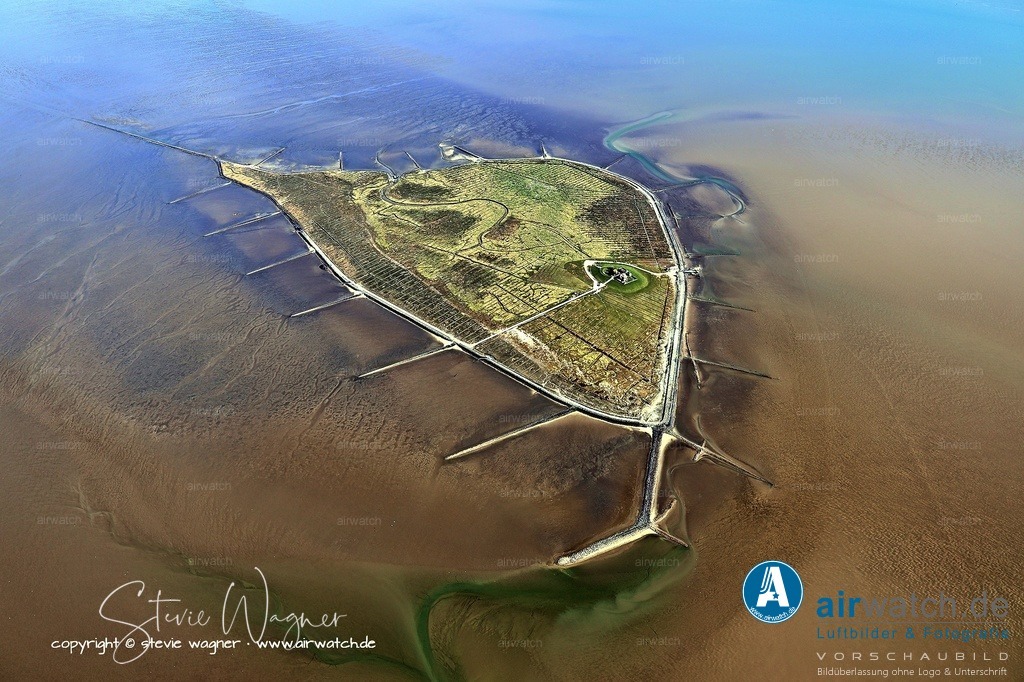 Hallig Südfall - Aktuelle Nutzung und Rungholt - Luftbild | Aktuelle Nutzung und Rungholt - Heute wird die 0,56 km² große Hallig von März bis November von nur zwei Personen (Vogelwartin und deren Mann) bewohnt und bewirtschaftet.  Die Hallig gilt als möglicher Standort des sagenumwobenen, versunkenen Hafens Rungholt, dessen Überreste im Watt gefunden wurden, und ist heute Teil des Nationalparks Schleswig-Holsteinisches Wattenmeer.