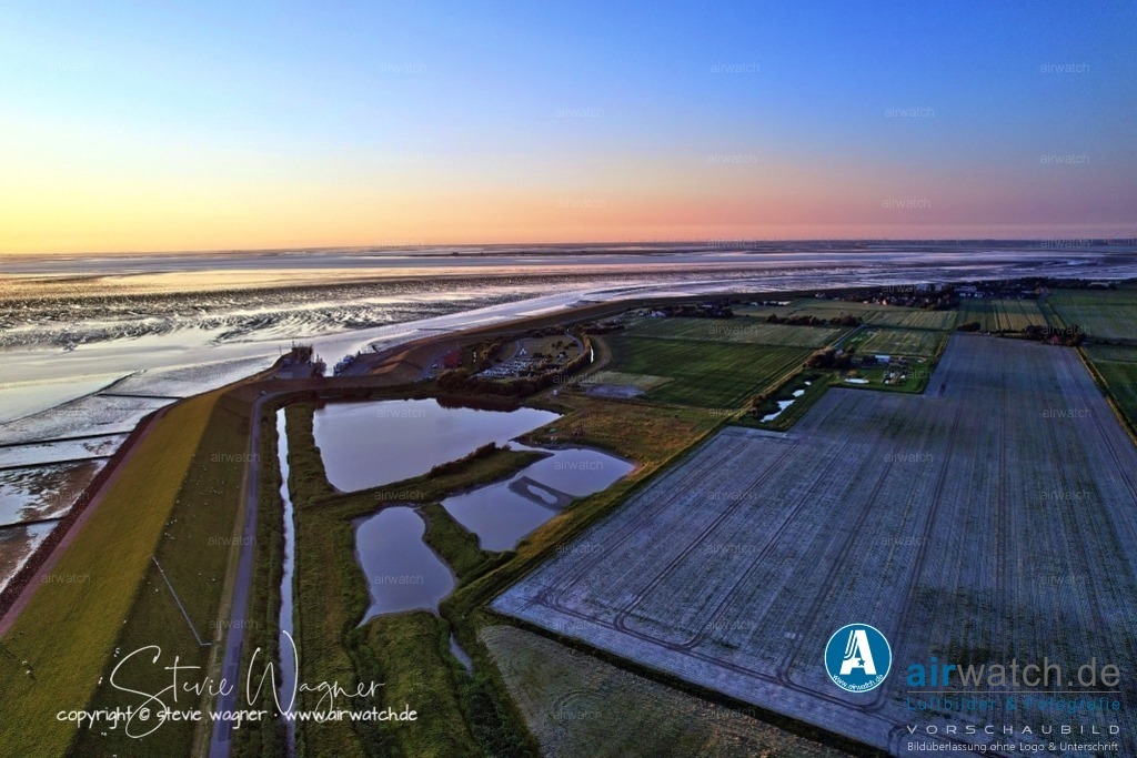 Luftbild Nordstrand, LangerDeich, Dreisprung, Püttenweg, Trendermarsch, Westen, Fuhlehörn, Husumer Bucht | Luftbild Nordstrand, LangerDeich, Dreisprung, Püttenweg, Trendermarsch, Westen, Fuhlehörn, Husumer Bucht - Nordstrand ist eine Marschinsel in Schleswig-Holstein an der deutschen Nordseeküste und Teil des UNESCO-Weltnaturerbes Wattenmeer. Die Insel ist bekannt für ihre ruhige, grüne Landschaft, weite Felder, Salzwiesen und einen gut erhaltenen Naturraum, der ideal für Erholung und Naturliebhaber ist. Das „Grüne Wegshörn“ bezeichnet eine Landzunge oder eine charakteristische Stelle auf Nordstrand, die landschaftlich hervorsticht und möglicherweise Teil eines Wanderwegenetzes ist, das durch die unberührte Marsch führt.