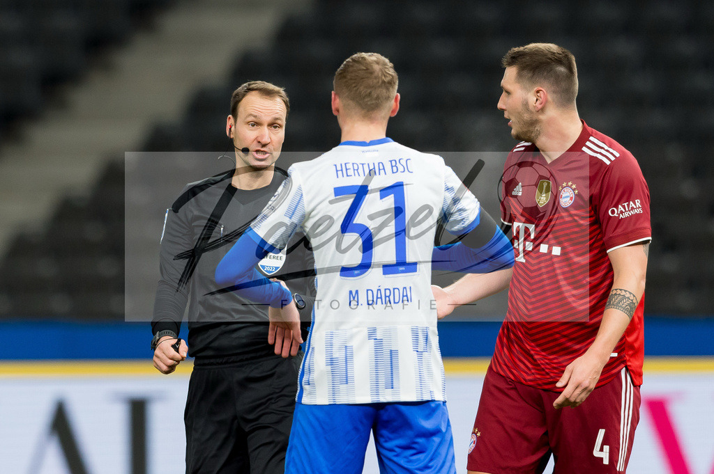 BSCFCB20220123_251 | Fussball, Herren: Schiedsrichter Bastian Dankert spricht mit Marton Dardai (Hertha BSC) und Niklas Suele (FC Bayern Muenchen) bei dem Spiel der 1. Bundesliga zwischen Hertha BSC und FC Bayern Muenchen im Olypiastadion am 23.01.2022 in Berlin, Deutschland.DFB / DFL REGULATIONS PROHIBIT ANY USE OF PHOTOGRAPHS AS IMAGE SEQUENCES AND/OR QUASI-VIDEO. - Realisiert mit Pictrs.com
