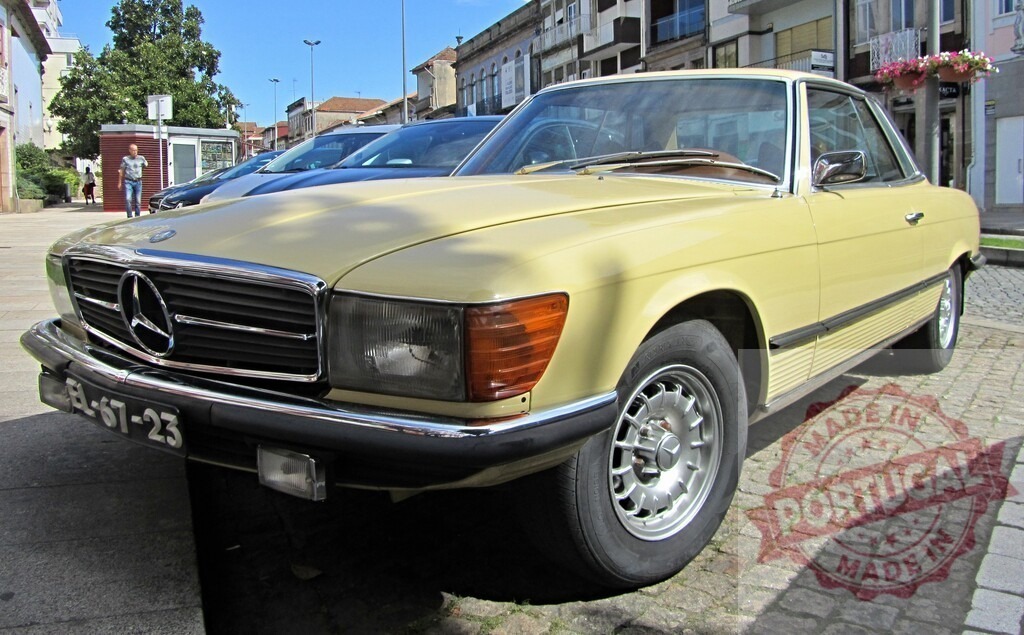 Classic Mercedes-Benz 450 SLC parked in urban setting, showcasing vintage automotive design | Beige Mercedes-Benz 450 SLC parked on a cobblestone street, embodying timeless elegance and automotive history - Realisiert mit Pictrs.com