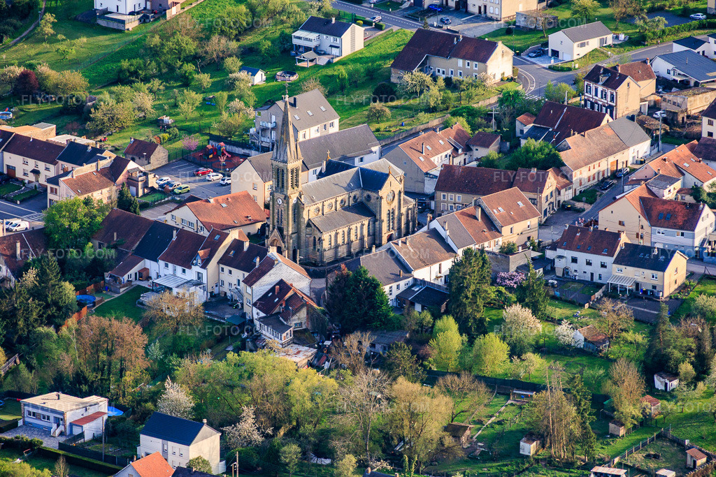 Aerial view: Saint-Denis Church in Farschviller in the state Moselle, France. – Photo: IMG_154661.jpg taken on 04/17/2026 by Werner Riehm/FLY-FOTO.com – Resolution of the original: 6000 x 4000 px