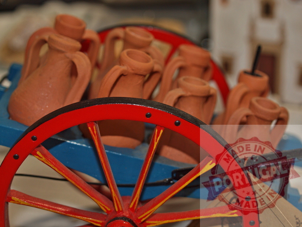 Miniature pottery jugs on a traditional wooden cart | Terracotta jugs loading a blue and red souvenir cart, displaying handmade craftsmanship - Realized with Pictrs.com