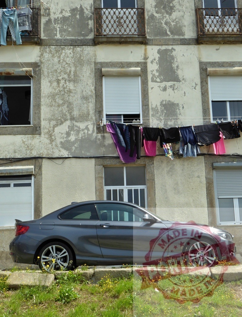 BMW car parked in front of weathered building with clothesline | Modern car parked by old urban building with laundry hanging from a clothesline - Realized with Pictrs.com