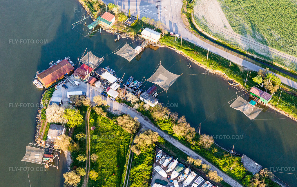 Aerial view: River net fishermen on the canal in Porto Garibaldi in Emilia-Romagna in the district Porto Garibaldi in Comacchio in the state Ferrara, Italy. – Photo: IMG_098704.jpg taken on 04/06/2017 by Werner Riehm/FLY-FOTO.com – Resolution of the original: 5472 x 3446 px