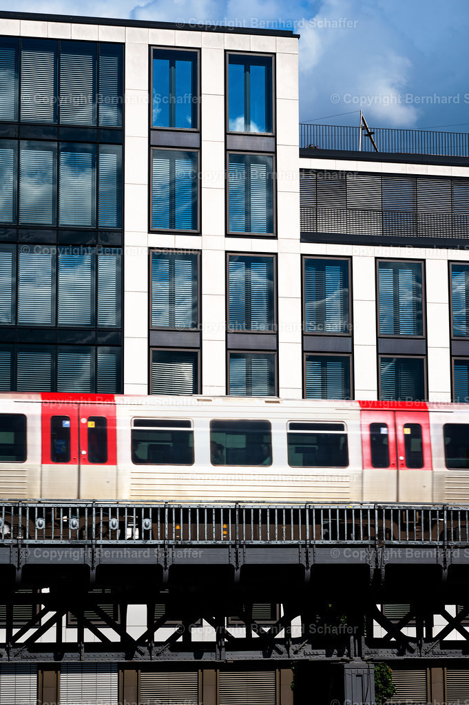 Metro und Geschäftswelt | Die Vorbeifahrt eines Metro Zuges an einem Gewerbekomplex in Hamburg / Deutschland. - Realisiert mit Pictrs.com