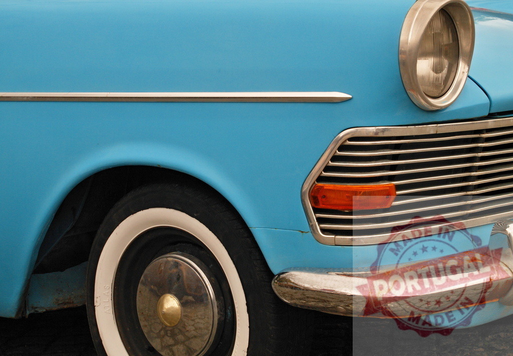 Light blue vintage car parked showing front wheel, headlight, bumper and grill | Close-up of a light blue vintage car parked on the street, showing details of its front wheel, headlight, bumper, and grill - Realized with Pictrs.com