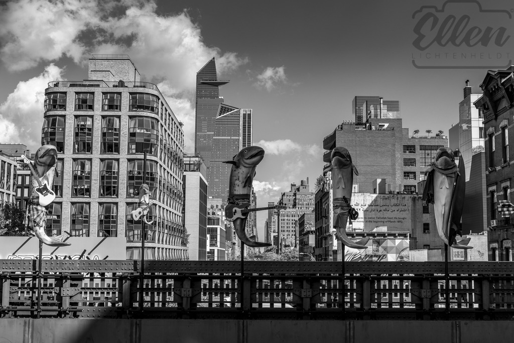 Urban Surrealism | Whimsical sculptures rise above the streets of New York — fish with guitars dancing against the city skyline. A surreal encounter between art and architecture, where imagination disrupts the rhythm of everyday life. - Realisiert mit Pictrs.com