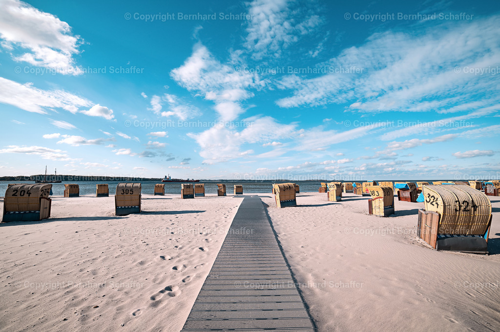 Holzweg zum Sandstrand | Ein Weg aus Holzbrettern führt durch den Sandstrand an vielen Strandkörben vorbei bis zur Ostsee. - Realisiert mit Pictrs.com