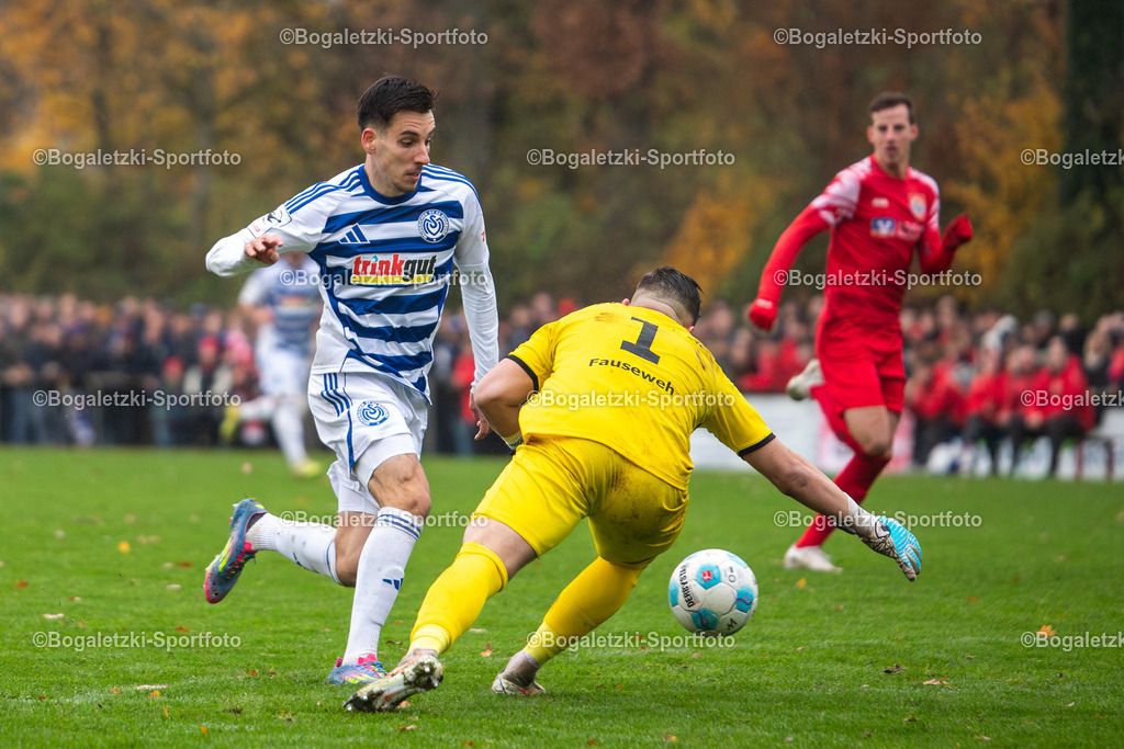 Fussball, Niederrheinpokal, SV Sonsbeck - MSV Duisburg, 16.11.2025, Willy-Lemkens-Sportpark | 16.11.2025, Fussball, Niederrheinpokal, SV Sonsbeck - MSV Duisburg: Connor Noß (MSV Duisburg #14) drückt den Ball an Torwart Jan Fauseweh (SV Sonsbeck #1) vorbei, bevor er gefoult wird - Realisiert mit Pictrs.com