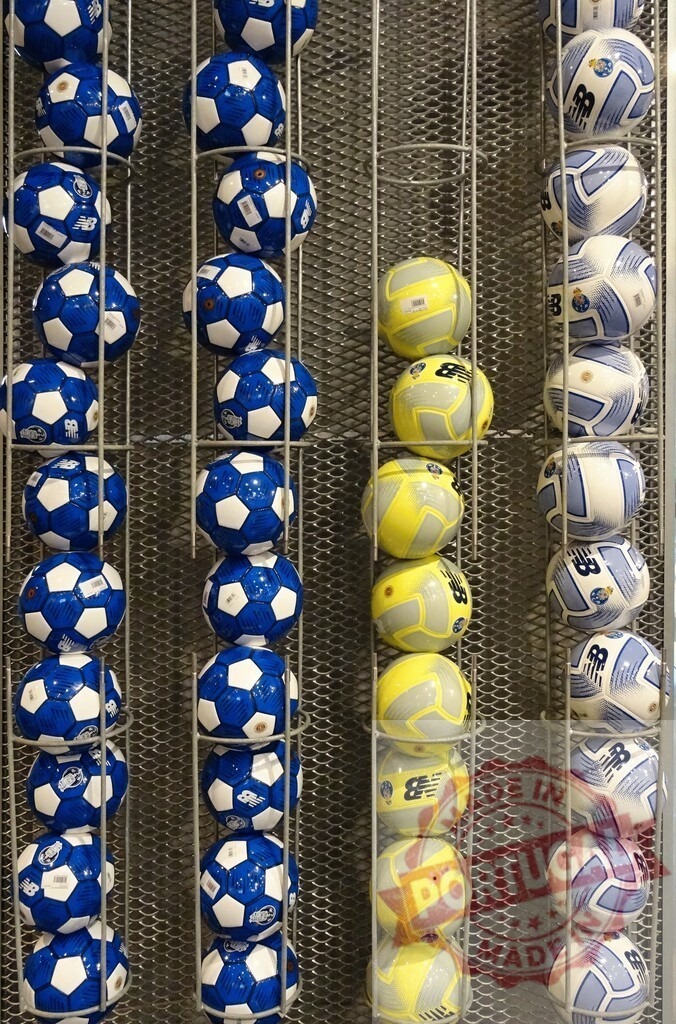 Retail displaying soccer balls on metal racks | Soccer balls for sale arranged in vertical rows on a store rack - Realisiert mit Pictrs.com