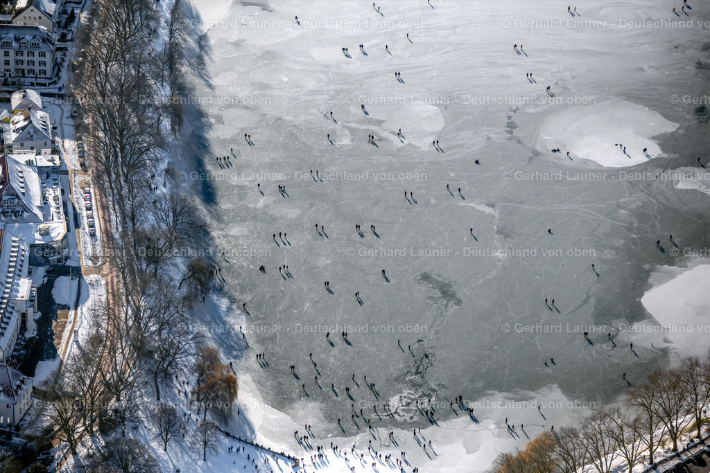 4043954 | MüNSTER 13.02.2021  Spaziergänger und Passanten laufen auf der Eisschicht der zugefrorenen Uferbereiche der See - Oberfläche des Aasee im Ortsteil Pluggendorf in Münster im Bundesland Nordrhein-Westfalen, Deutschland. // Wintry snowy strollers and passers-by walk on the ice sheet of the frozen bank areas of the lake - surface of Aasee in the district Pluggendorf in Muenster in the state North Rhine-Westphalia, Germany. Foto: Gerhard Launer
