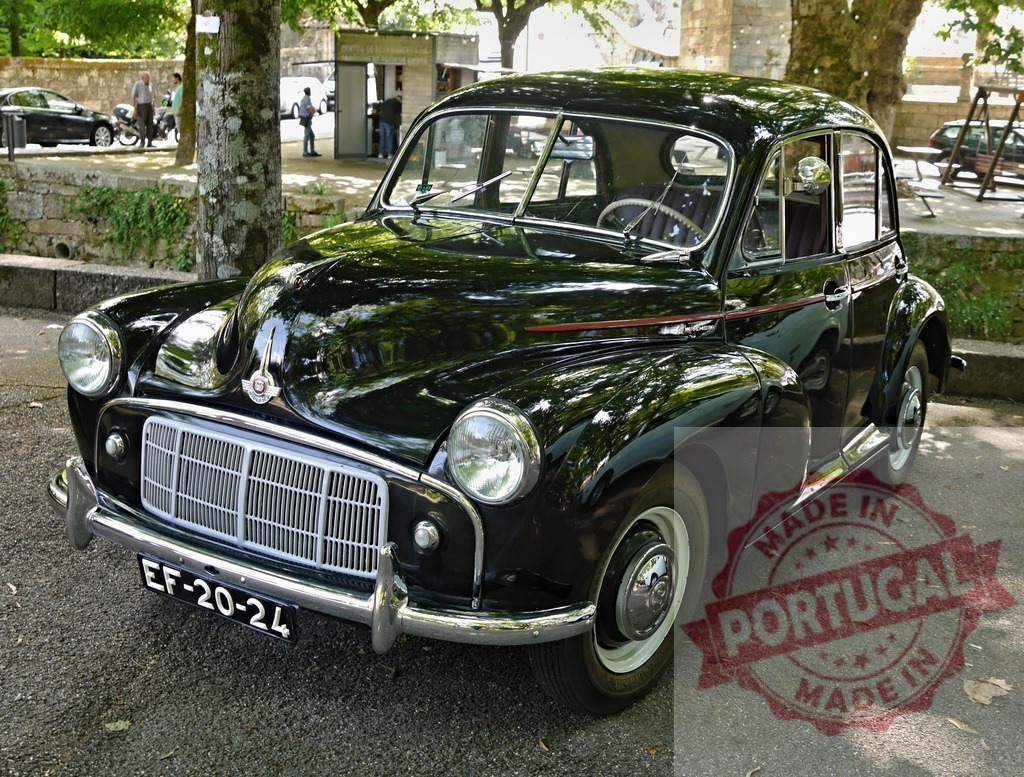 Morris Minor black vintage car parked outdoors | Morris Minor classic automobile standing on asphalt under trees - Realized with Pictrs.com