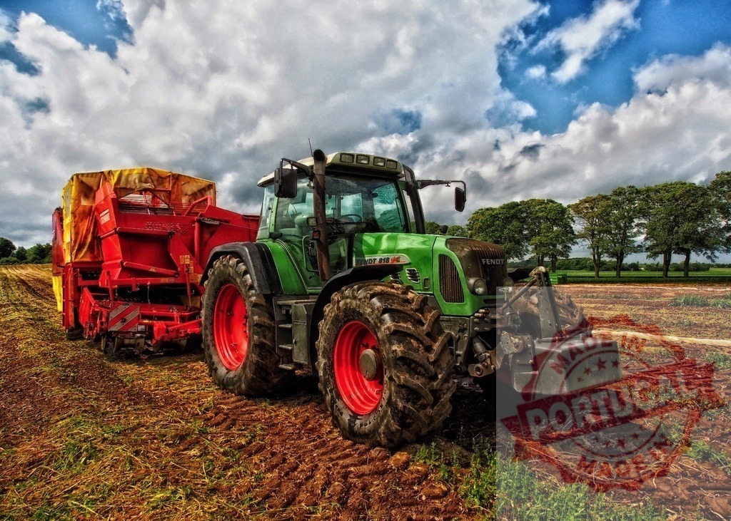 Fendt tractor pulling potato harvester in field | Green Fendt tractor operating a red potato harvester on a farm field under cloudy sky - Realized with Pictrs.com