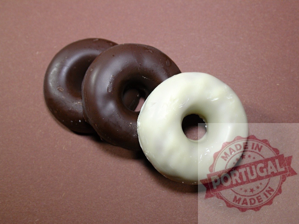 Chocolate and vanilla glazed donuts on brown surface | Three ring donuts, two chocolate and one vanilla, showing sweet dessert food - Realisiert mit Pictrs.com