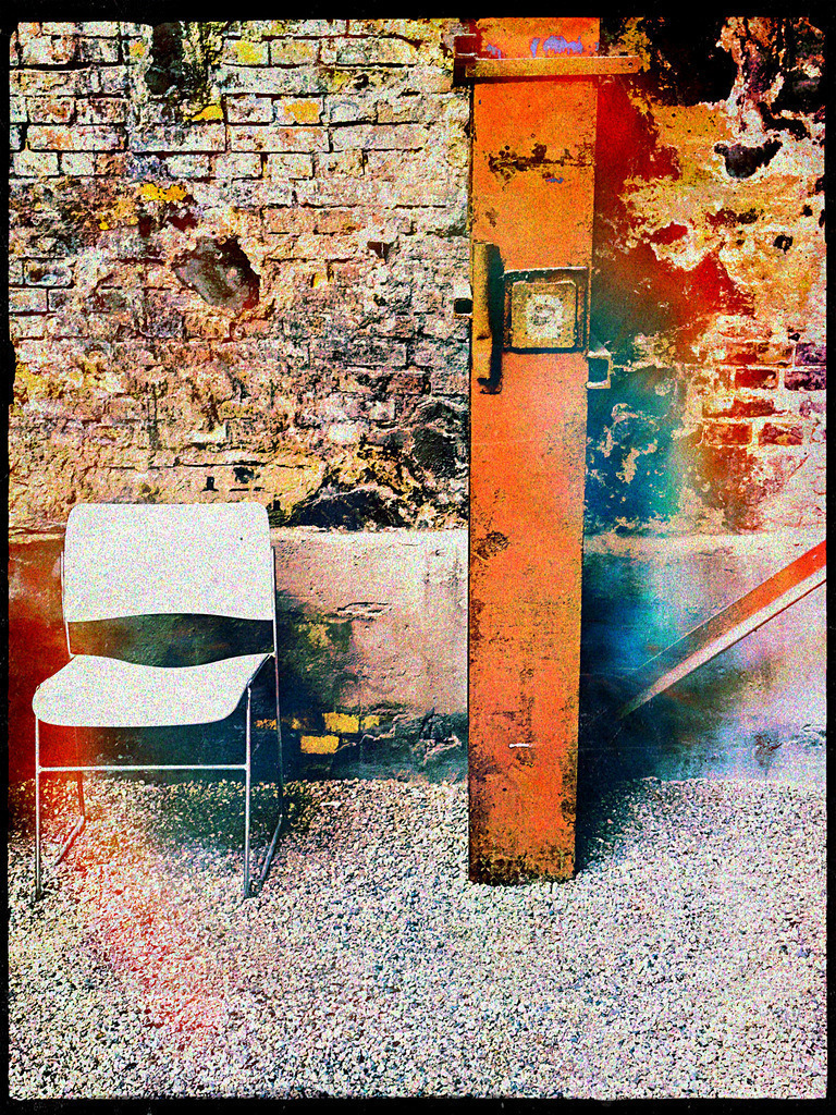 Stimmung der Stille | Dieses fotografische Kunstwerk vereint den rauen Charme eines vergessenen Ortes mit der stillen Präsenz eines leeren Stuhls und eines rostigen Metallpfostens. Die verwitterte Backsteinwand und die farblichen Verfremdungen erzählen von vergangenen Tagen, während das Bild durch seine Textur und Kontraste Emotionen weckt. Ein perfektes Statement für Liebhaber urbaner Ästhetik und abstrakter Kunst, das in jedem Raum eine Geschichte von Zeit und Raum erzählt. - Realisiert mit Pictrs.com