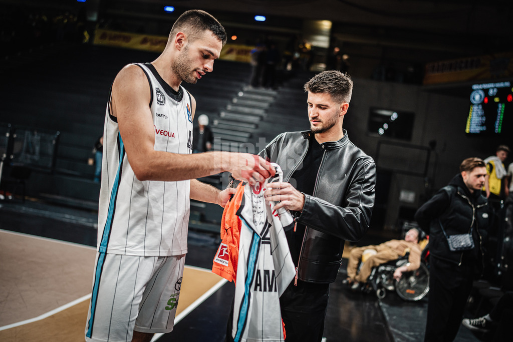 Basketball | Männer | Saison 2024/2025 | easyCredit Basketball Bundesliga | 4. Spieltag | Veolia Towers Hamburg vs. EWE Baskets Oldenburg | 06.10.2024 | v.l. Benedikt Turudic (#44, Veolia Towers Hamburg) und Nikola Vasilj (FC. St Pauli) Fußball beim Trikottausch
