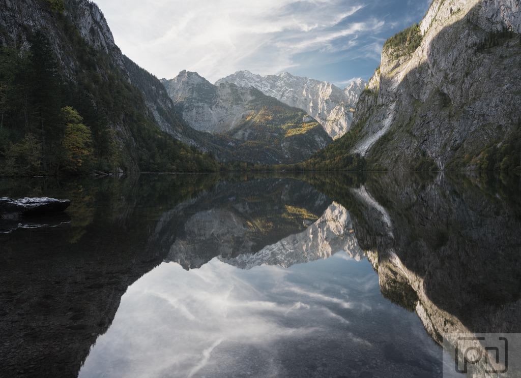 Ein Sonnenaufgang am Obersee  | Ein Sonnenaufgang am Obersee in Berchtesgaden ist ein wahres Naturschauspiel, das die Seele berührt. Wenn die ersten Strahlen der Sonne die umliegenden Berge und den klaren See streifen, erwacht die Welt in einer magischen Stille. Das warme Licht taucht die Szenerie in sanfte Gold- und Rosatöne und spiegelt sich in der glatten Wasseroberfläche des Obersee wider.