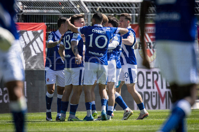 German 3rd Division, Viktoria Koeln vs. Energie Cottbus, 26.04.2026 | KOELN, GERMANY - APRIL 26, 2026:  Erik Engelhardt (Energie Cottbus, 18) celebrates scoring his team's first goal with teammates during the 3rd division match on gameday 35 between Viktoria Koeln vs. Energie Cottbus at the Sportpark Hoehenberg on April 26, 2026 in Koeln, Germany. DFL REGULATIONS PROHIBIT ANY USE OF PHOTOGRAPHS AS IMAGE SEQUENCES AND/OR QUASI-VIDEO.