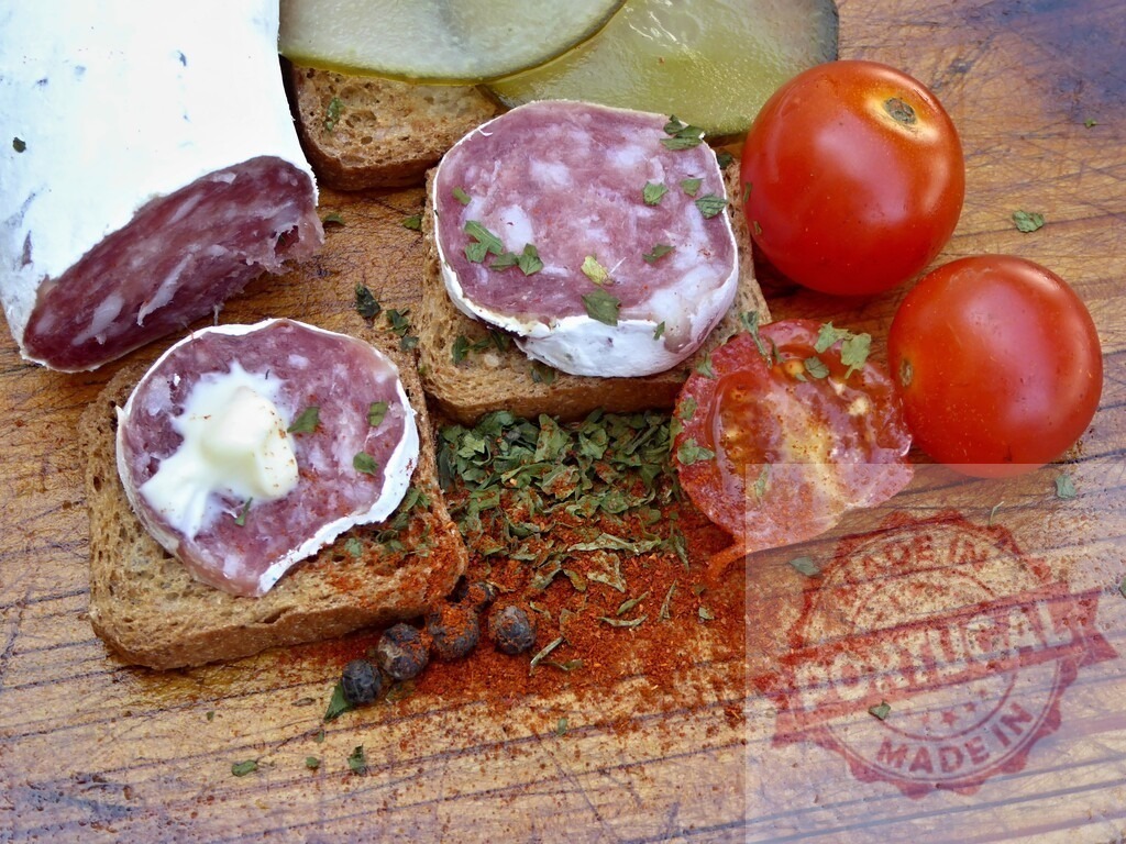 Salami appetizer with seasoned bread and fresh tomatoes | Salami slices with bread, tomatoes, and spices creating a rustic snack - Realized with Pictrs.com