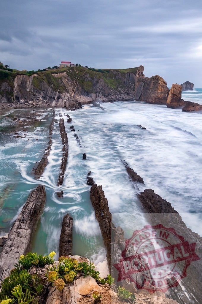 Playa de la Arnia flysch formations with ocean waves | Ocean waves flowing over dramatic flysch rock formations along the Cantabrian coastline in Spain - Realized with Pictrs.com