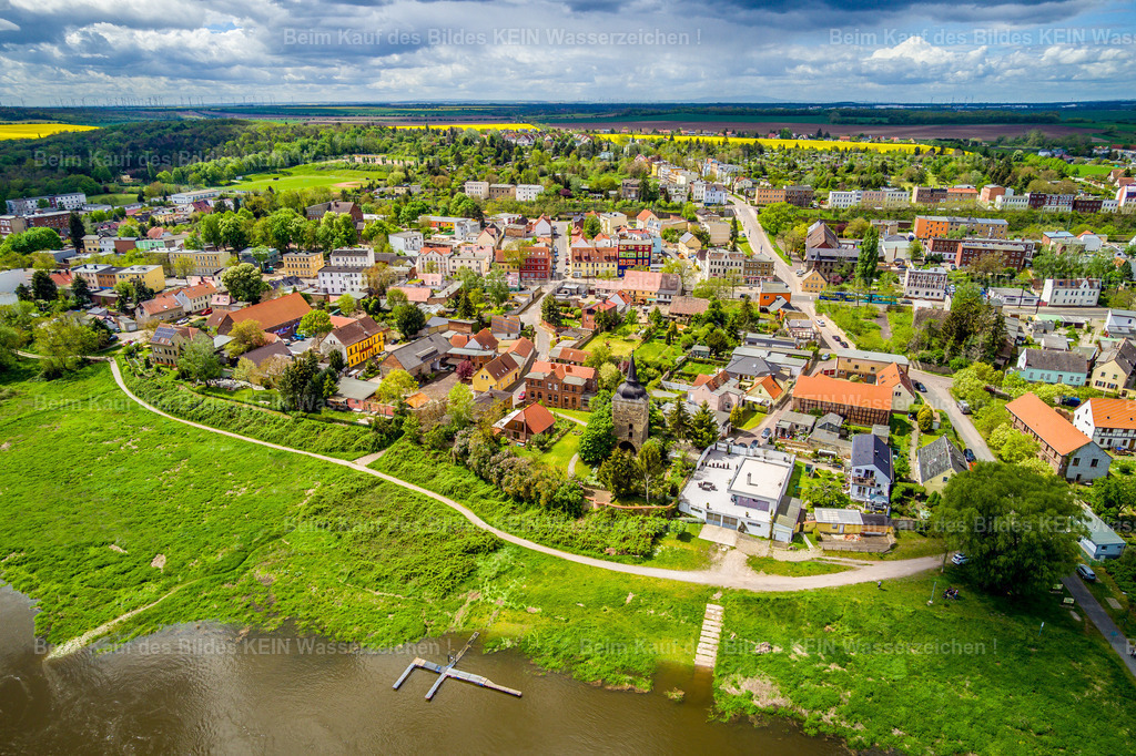 Magdeburg Westerhüsen bei Elbfähre-0022 | Westerhüsen gehört zu den Stadtteilen Magdeburgs, in denen die Nähe zur Elbe und die gewachsene Ortsgeschichte den Charakter des Wohnumfelds prägen. Rund um die historische Kirche St. Stephanus finden sich ältere Wohnhäuser, Gärten und grüne Freiflächen. Der Ort wirkt an vielen Stellen ruhiger und dörflicher als die dicht bebauten Viertel im Zentrum.  –  –  Die Elbe liegt direkt vor der Tür und macht den besonderen Reiz dieser Lage aus. Der Uferbereich lädt dazu ein, draußen unterwegs zu sein und die Landschaft zu genießen. Zwischen dem alten Ortskern und dem Fluss entsteht ein Wohnumfeld, in dem Geschichte und Natur eng zusammengehören.  –  –  St. Stephanus erinnert an die lange Vergangenheit Westerhüsens. Der Ort wurde bereits im Jahr 840 erstmals urkundlich erwähnt. Vom historischen Kirchenbau blieb nach den Zerstörungen des Zweiten Weltkriegs der Westturm erhalten, der bis heute das Ortsbild prägt. Solche Gebäude geben dem Stadtteil eine eigene Identität und verbinden die Gegenwart mit den Generationen, die hier zuvor gelebt haben.  –  –  Westerhüsen zeigt eine besonders ruhige Seite Magdeburgs: Wohnen nahe am Wasser, viel Grün in der Umgebung und ein historisch gewachsener Ortskern. Wer sich für das Leben in den unterschiedlichen Stadtteilen interessiert, entdeckt hier ein Magdeburg, das sich seinen eigenen Charakter bewahrt hat. - Realisiert mit Pictrs.com