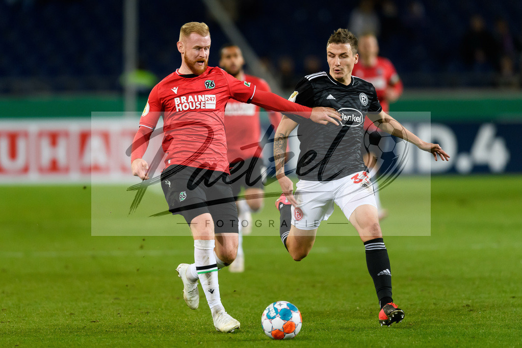 H96DUS20211027_021 | Fussball, Herren: Sebastian Kerk (Hannover 96) und Marcel Sobottka (Fortuna Duesseldorf) im Zweikampf bei dem Spiel der 2. Runde im DFB-Pokal zwischen Hannover 96 und Fortuna Duesseldorf in der HDI-Arena am 27.10.2021 in Hannover, Deutschland.DFB / DFL REGULATIONS PROHIBIT ANY USE OF PHOTOGRAPHS AS IMAGE SEQUENCES AND/OR QUASI-VIDEO. - Realisiert mit Pictrs.com