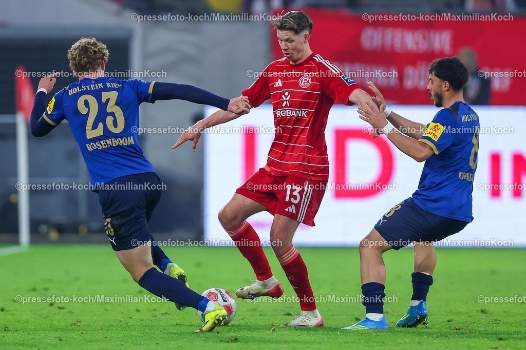 F9510042601111 | 10.04.2026, Fußball, Fortuna Düsseldorf - Holstein Kiel, 2. Fußball Bundesliga, Herren, Merkur Spiel-Arena, 29. Spieltag, Saison 2025 2026: Cedric Itten&nbsp;(Fortuna Düsseldorf #13) im Zweikampf gegen Lasse Rosenboom&nbsp; (Holstein Kiel #23) Umut Tohumcu&nbsp; (Holstein Kiel #08)   DFB regulations prohibit any use of photographs as image sequences and or quasi-video.