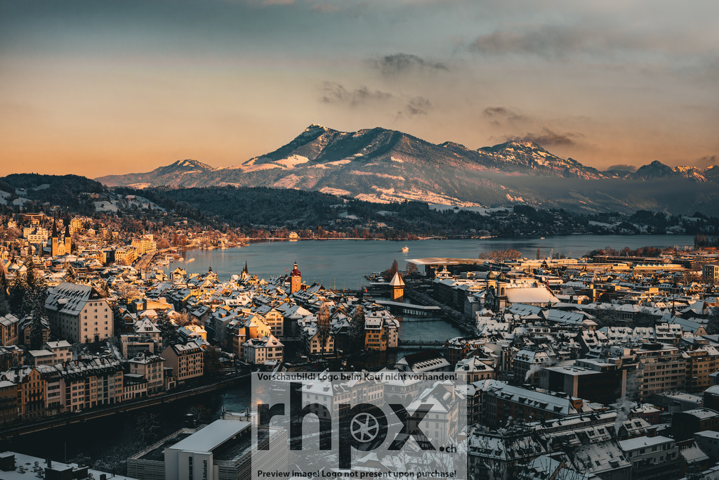 Aussicht auf verschneites Luzern mit Rigi im Hintergrund | Stadt. Berg. Licht. Das warme Abendlicht vergoldet die verschneiten Dächer von Luzern und lässt den majestätischen Rigi im Hintergrund erstrahlen. Ein Panorama voller Ruhe, das die einzigartige Verbindung von Stadt, See und Alpenlandschaft perfekt einfängt. Wähle unter "Produktauswahl" dein Wunschformat: Vom klassischen Wandbild über Puzzle &amp; Tassen bis zum digitalen Download (z.B. als Handy-Hintergrund). - Realisiert mit Pictrs.com