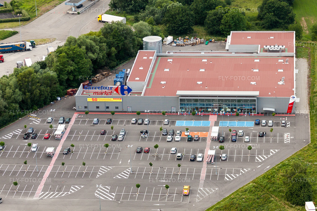 Aerial view: Branch of the supermarket and parking lot of the Carrefour Market Lauterbourg in Scheibenhard in the state Bas-Rhin, France. – Photo: IMG_28735.jpg taken on 06/14/2010 by Werner Riehm/FLY-FOTO.com – Resolution of the original: 4752 x 3168 px