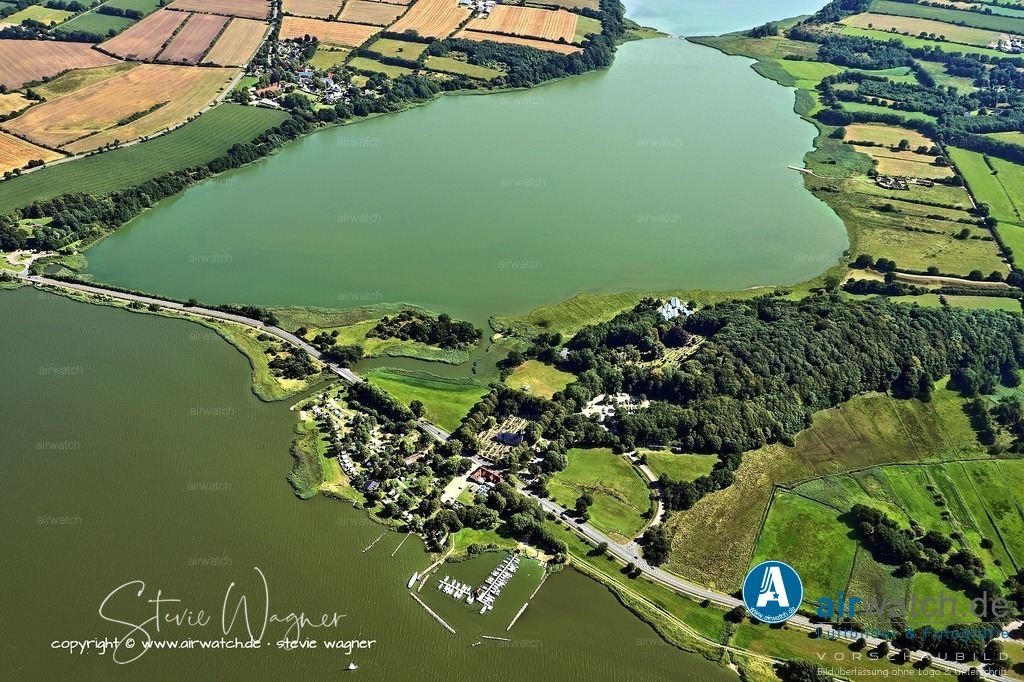 Haithabu - Wirtschaft und Handel - Luftbild | Archäologische Funde belegen einen intensiven Austausch mit weit entfernten Regionen: Pelze, Sklaven, Eisen, Waffen, Glasperlen, Stoffe und Luxusgüter wie Seide und Gewürze wurden gehandelt. Die Stadt unterhielt enge Beziehungen zu anderen Handelsplätzen wie Birka (Schweden), Kaupang (Norwegen) und Dorestad (Niederlande).