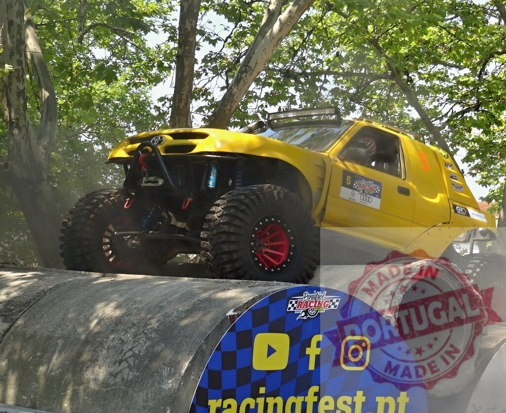 Yellow offroad vehicle climbing concrete pipes during competition | Modified offroad car overcoming obstacle during an extreme motorsport competition - Realized with Pictrs.com