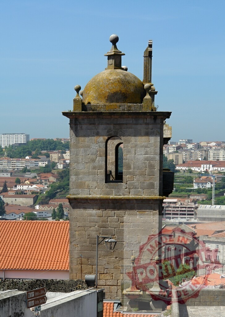 Historic stone tower overlooking Porto city skyline. Porto - Portugal | Stone bell tower with dome, offering panoramic views of the city scape under a clear sky - Realized with Pictrs.com
