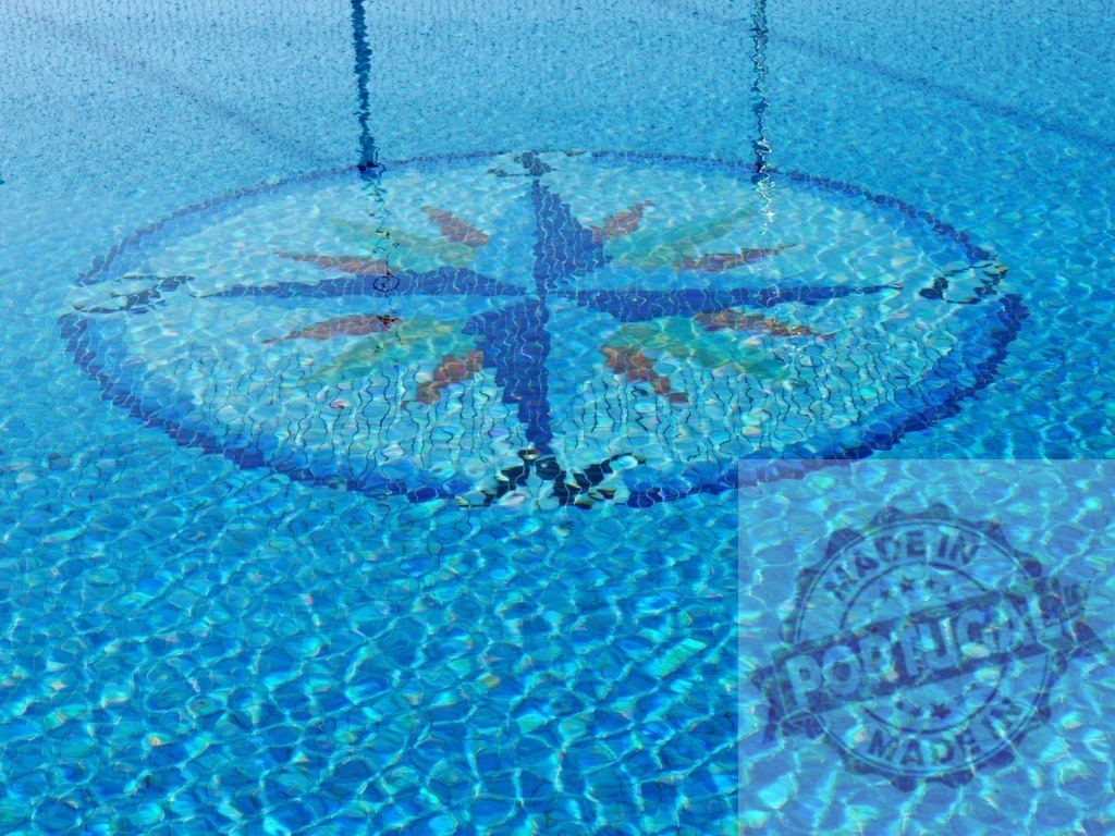 Swimming pool with blue mosaic compass rose design | Blue swimming pool water showing an underwater mosaic compass rose pattern - Realized with Pictrs.com