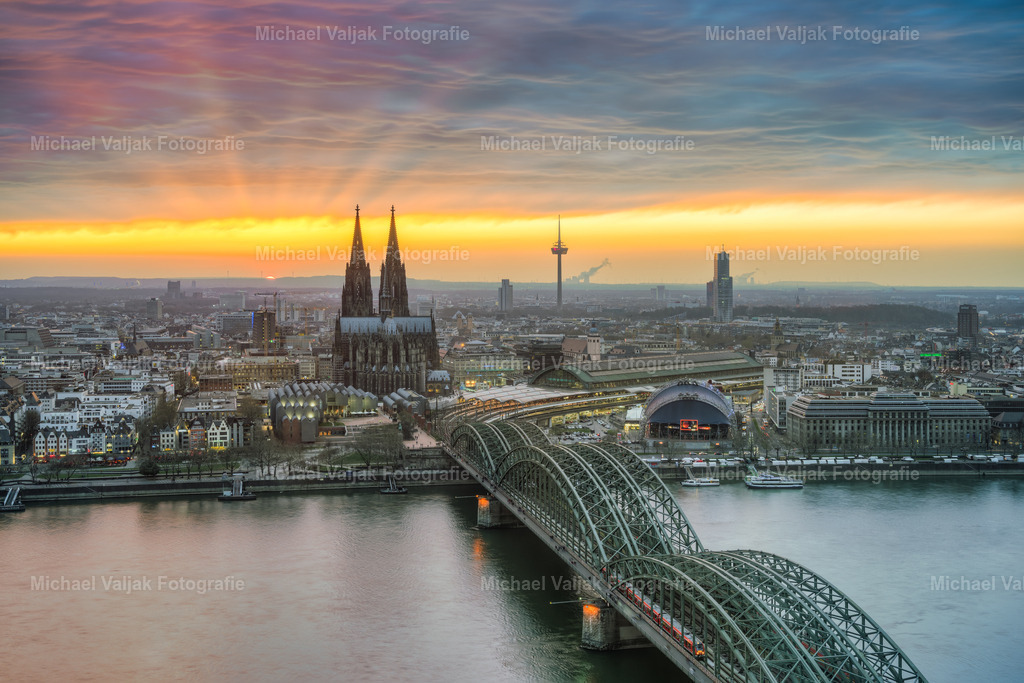 Sonnenuntergang in Köln | Blick über die Kölner Innenstadt bei einem herrlichen Sonnenuntergang. Fächerartig breiten sich die Sonnenstrahlen aus und leuchten in die Wolkendecke. - Realisiert mit Pictrs.com