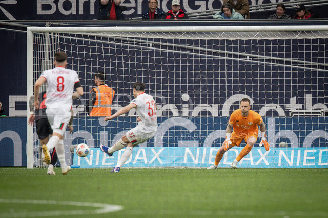 German Bundesliga, Bayer 04 Leverkusen vs. FC Augsburg, 18.04.2026 | LEVERKUSEN, GERMANY - APRIL 18, 2026 :  Penalty, Fabian Rieder (FC Augsburg, 32) scores against Keeper Mark Flekken (Bayer 04 Leverkusen, 1) setting to 1:2 during the German Bundesliga match on gameday 30 between Bayer 04 Leverkusen vs. FC Augsburg at BayArena on April 18, 2026 in Leverkusen, Germany. DFL REGULATIONS PROHIBIT ANY USE OF PHOTOGRAPHS AS IMAGE SEQUENCES AND/OR QUASI-VIDEO.