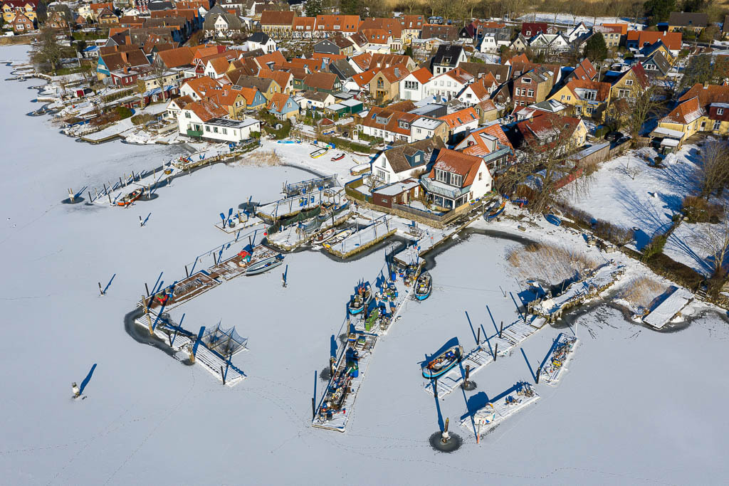 zeitenwende-farbe-01-05 | Im Eis der Schlei: Landungsbrücken und Boote in der Fischersiedlung Holm in Schleswig aus der Vogelperspektive - Realisiert mit Pictrs.com