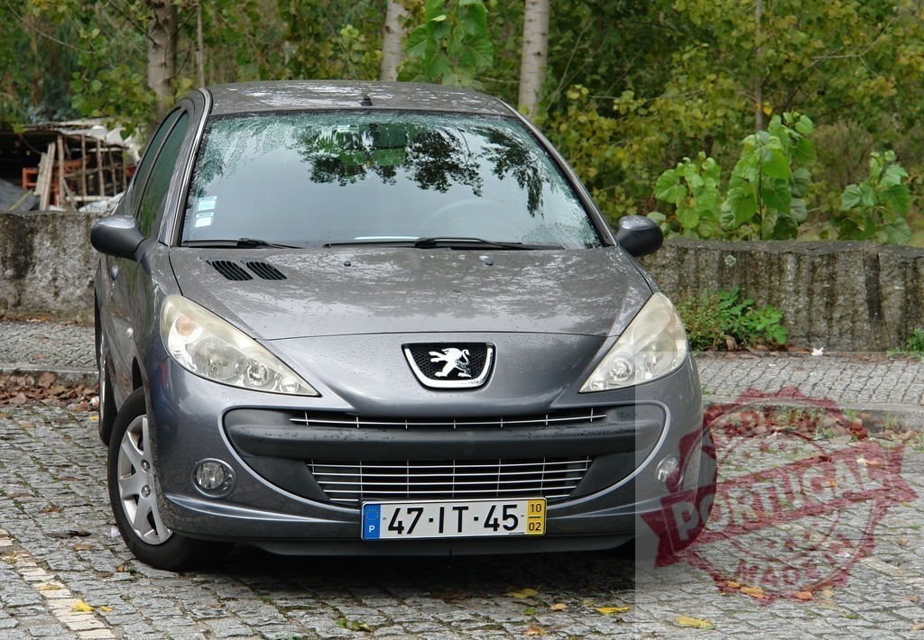 Peugeot 207 grey car parked on cobblestone in Portugal | Peugeot 207 hatchback car parked on a European cobblestone street - Realisiert mit Pictrs.com