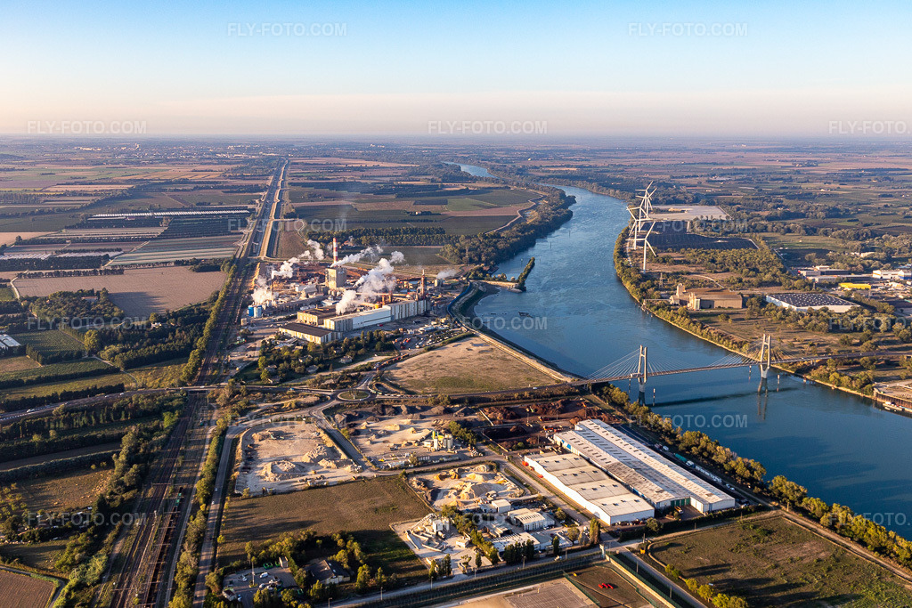 Aerial view: Production buildings of PROVENCE COMPOST and Fibre Excellence with port facilities on the banks of the Rhône River in Tarascon in the state Bouches du Rhone, France. – Photo: IMG_129576.jpg taken on 09/23/2021 by Werner Riehm/FLY-FOTO.com – Resolution of the original: 5340 x 3560 px