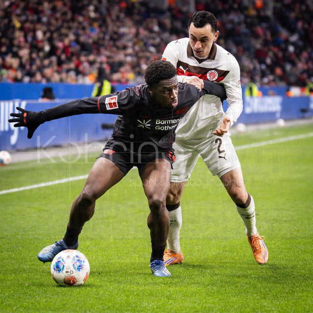 Bayer 04 Leverkusen vs. FC St. Pauli, 14.02.2026 | LEVERKUSEN, GERMANY - FEBRUARY 14:  Ernest Poku (Bayer 04 Leverkusen, 19) tackled by Manolis Saliakas (FC St. Pauli, 2) during the Bundesliga match (gameday 22)  between Bayer 04 Leverkusen vs. FC St. Pauli at BayArena on February 14, 2026 in Leverkusen, Germany. (Photo by Axel Kohring/Beautiful Sports Int.)DFL REGULATIONS PROHIBIT ANY USE OF PHOTOGRAPHS AS IMAGE SEQUENCES AND/OR QUASI-VIDEO.