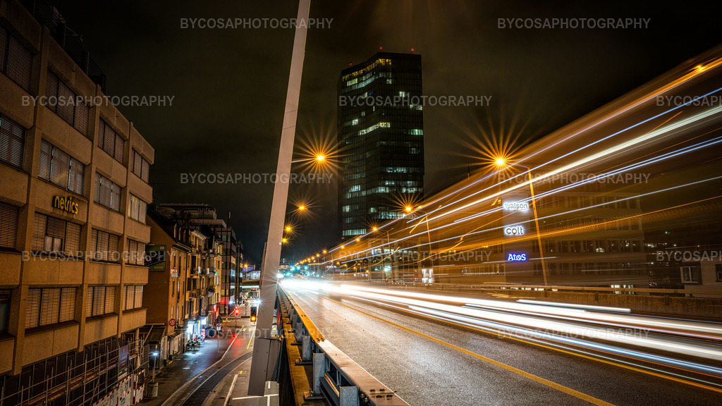 Hardbrücke Velocity _ Zürich in Motion | Eine dynamische und ausdrucksstarke nächtliche Stadtansicht, die den wahren Puls Zürichs einfängt. Langbelichtete Lichtspuren erstrecken sich über die Hardbrücke und erzeugen ein beeindruckendes Gefühl von Geschwindigkeit und Bewegung, während der Prime Tower im Hintergrund wie ein stiller Wächter der Stadt aufragt. Straßenlaternen erstrahlen in funkelnden Sternen, Spiegelungen glitzern auf dem nassen Asphalt, und die gesamte Szene verströmt eine moderne, industrielle Atmosphäre. Dieser FineArt-Druck ist perfekt für moderne Interieurs, Büros und alle Liebhaber des urbanen Lebens und der Nachtfotografie. - Realisiert mit Pictrs.com